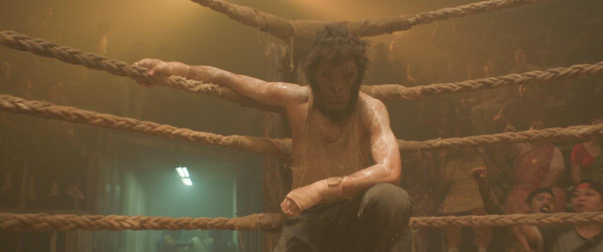 A man in a monkey mask awaits combat in the ring.
