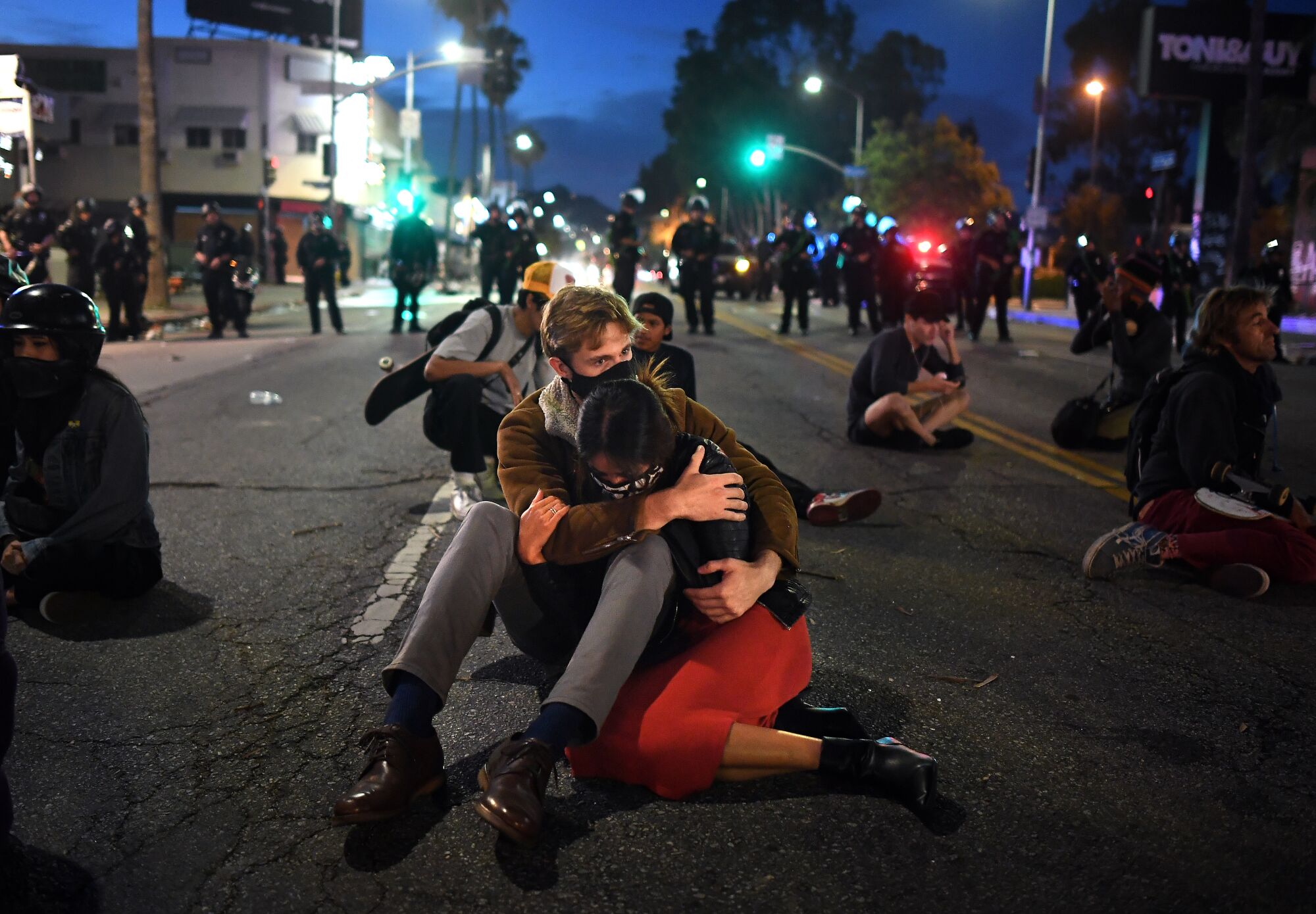 A couple console each other knowing they will be arrested along with protesters on Fairfax Avenue in Los Angeles.