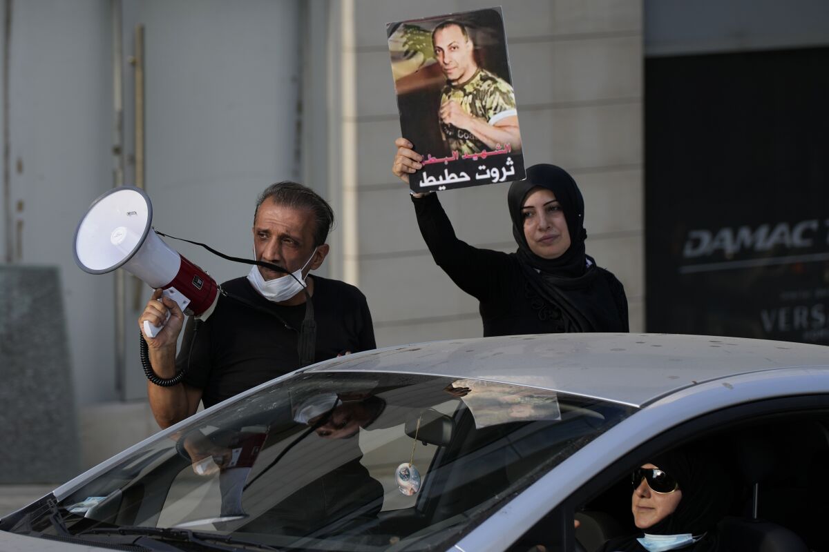 Ibrahim Hoteit, 51, left, and his wife, Hanan, lead a protest for the relatives of victims of the Aug. 4, 2020, Beirut port explosion in Beirut, Lebanon, Saturday, July 10, 2021. Hoteit, whose brother was killed in the blast, has become the face of calls for justice from the families of the victims. (AP Photo/Hassan Ammar)
