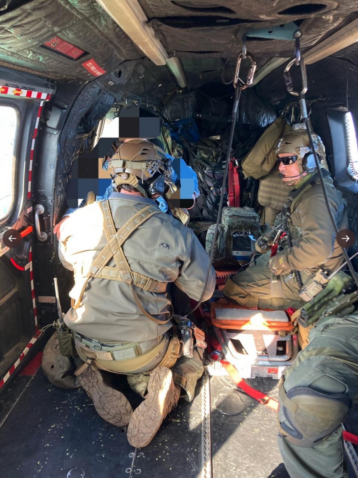 Rescue personnel inside a helicopter.