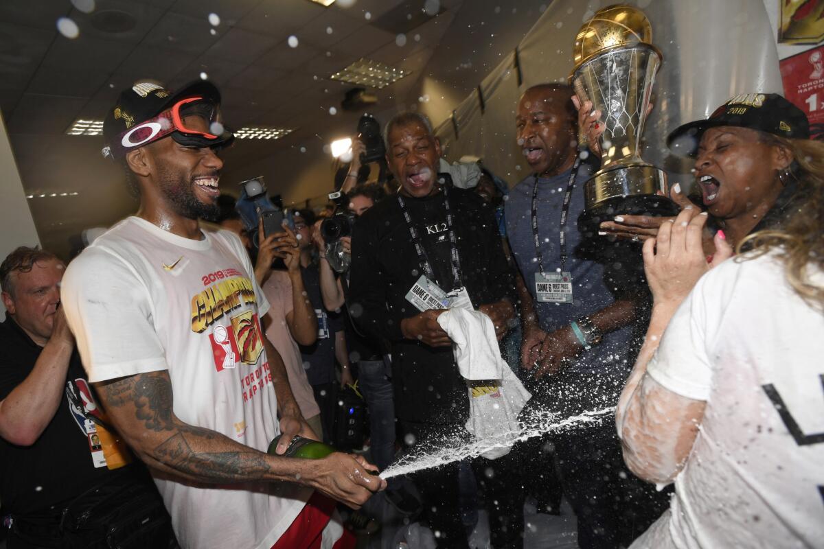 Raptors forward Kawhi Leonard sprays his mother Kim Robertson with champagne after Toronto defeated the Golden State Warriors to win the 2019 NBA championship.