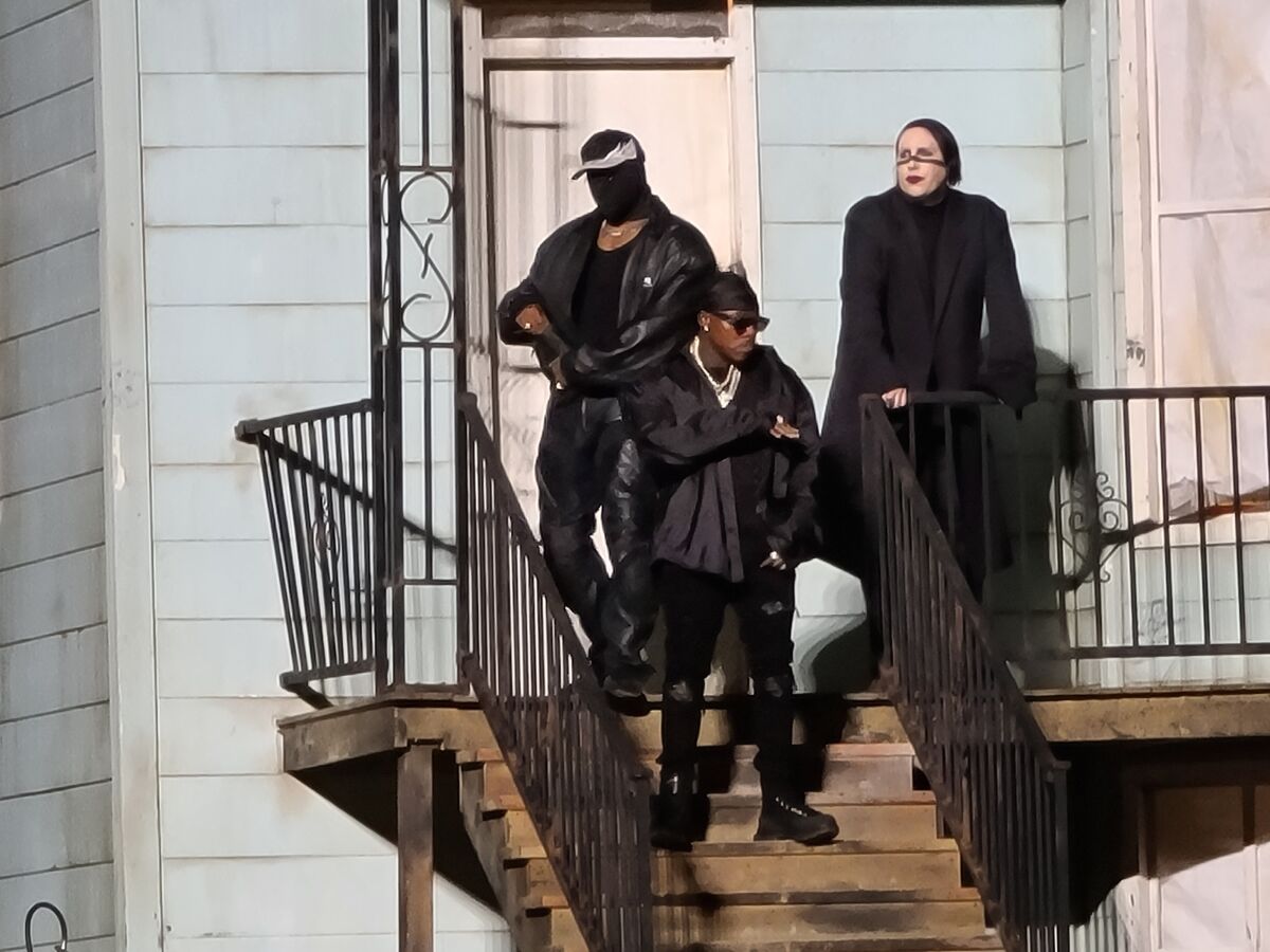Kanye West, DaBaby and Marilyn Manson standing on a staircase