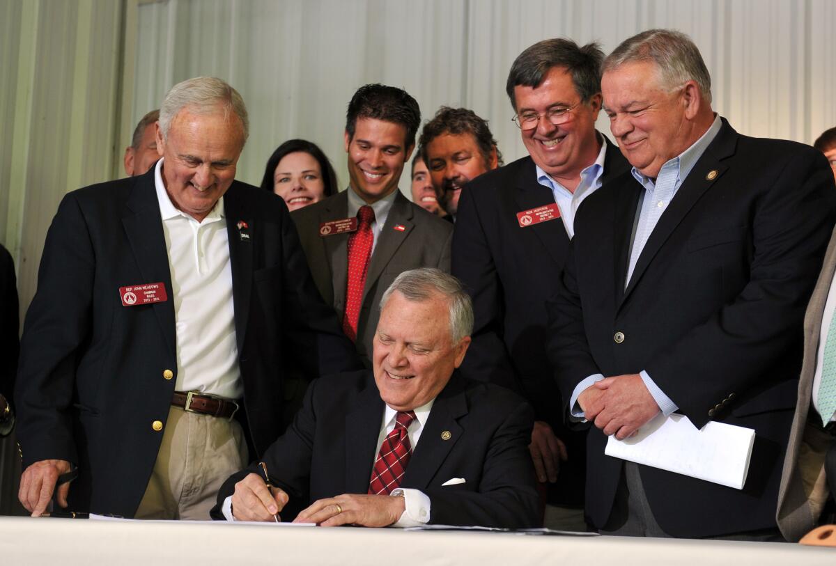 Surrounded by supporters of the legislation, Georgia Gov. Nathan Deal signs House Bill 60 into law Wednesday. The bill makes several changes to the state's gun laws.