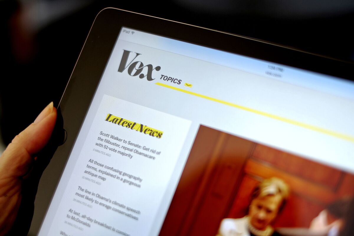 The Vox website is displayed on an iPad. 