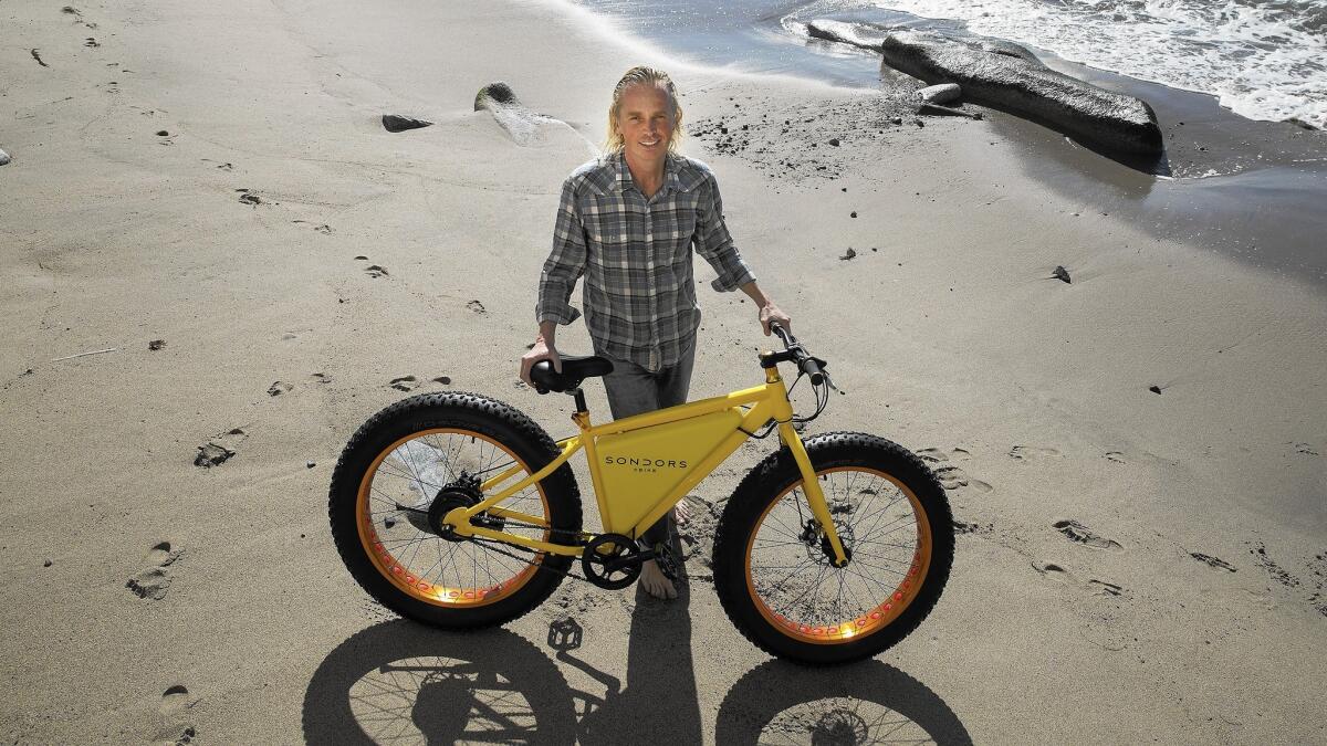 Storm Sonders shows his electric bike on the beach near his home in Malibu. Sonders is a surfer and entrepreneur who struggles with Asperger's syndrome.