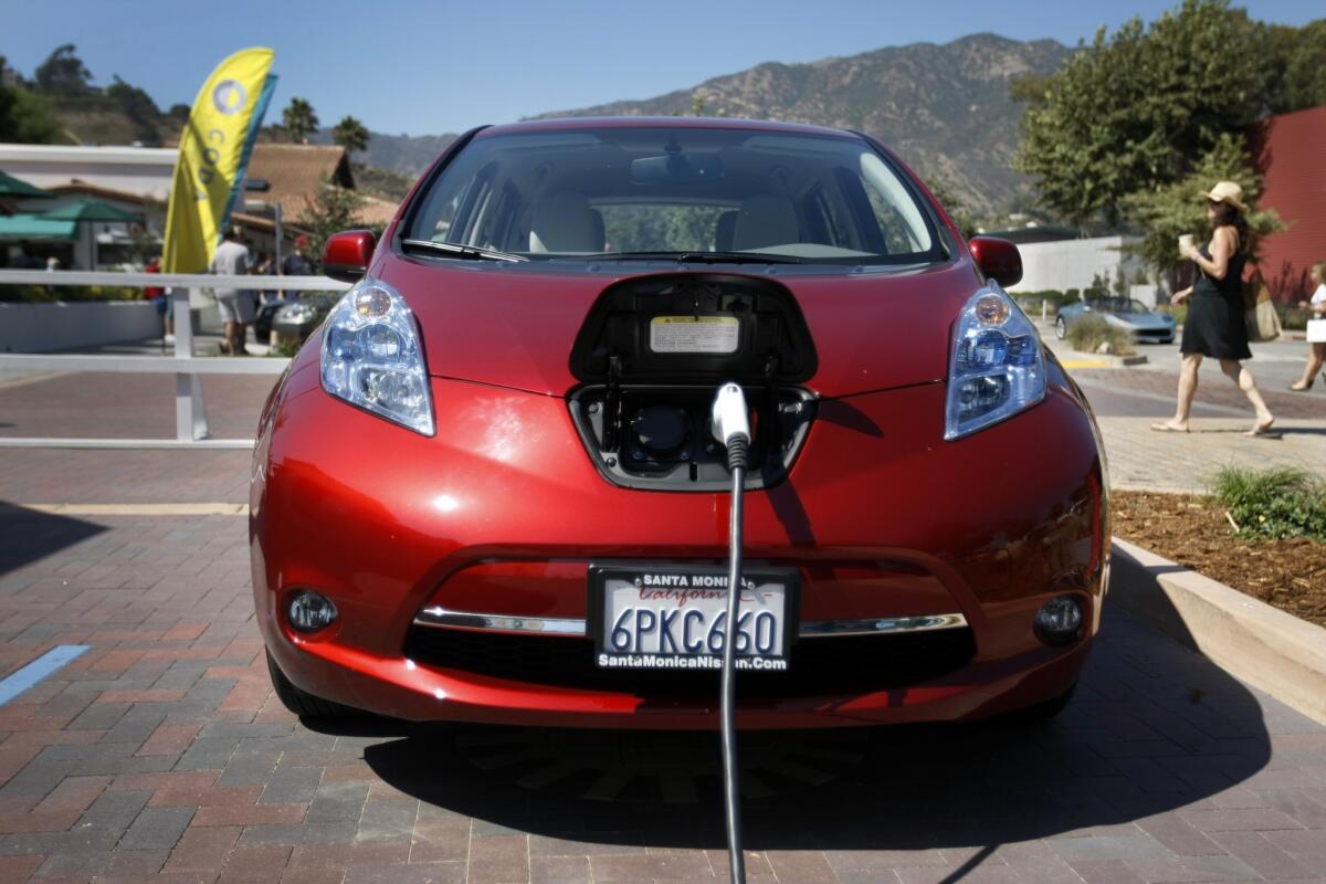 An electric Nissan Leaf is plugged in at a charging station in Malibu.
