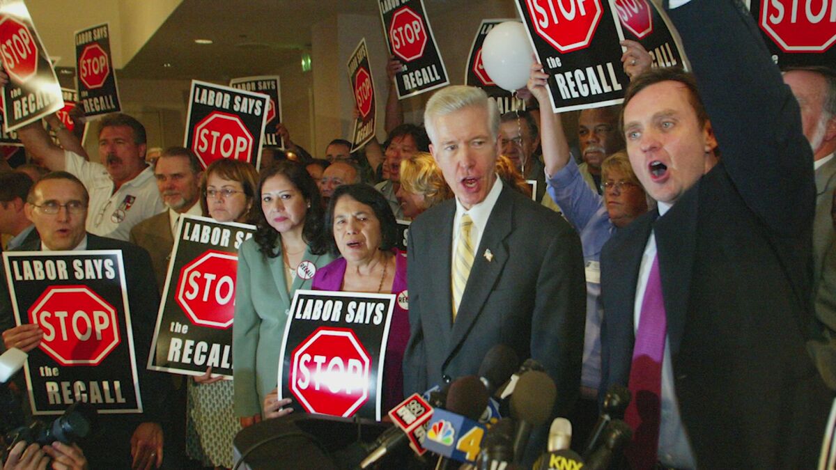 Supporters flank Gov. Gray Davis with "Labor Says Stop the Recall" signs.