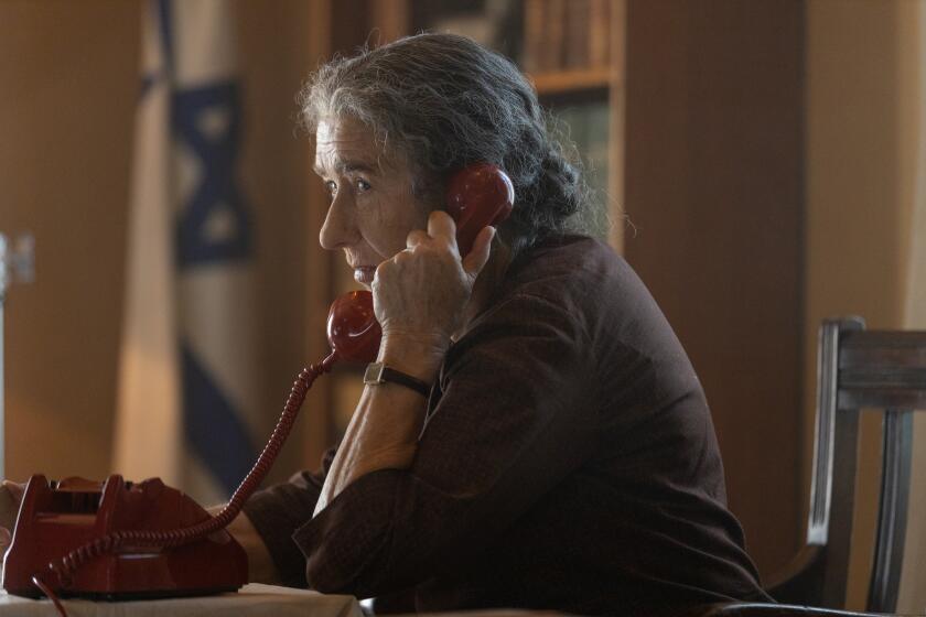 Helen Mirren, playing Israeli Prime Minister Golda Meir, answers the phone in the movie "Golda."