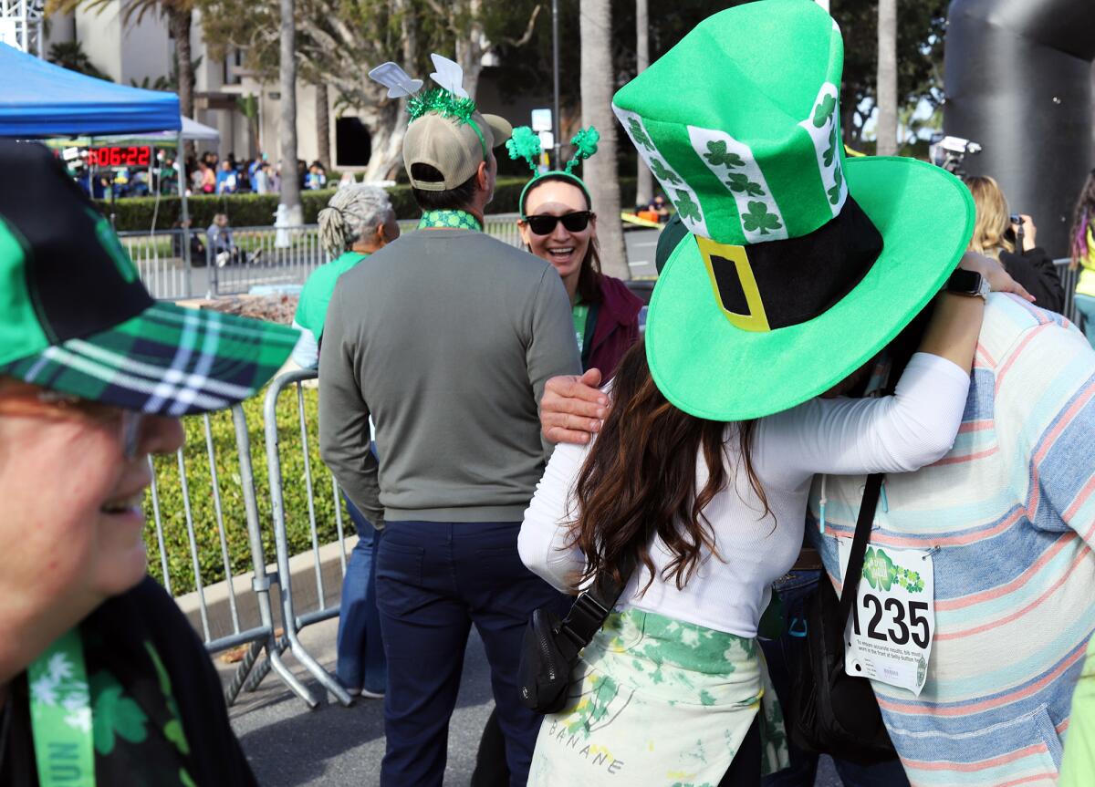 Jorge Martinez of Irvine, wearing his big St. Patrick's Day hat gets a hug.