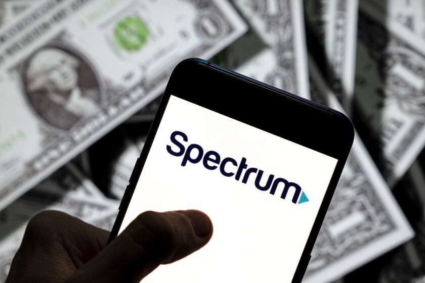 CHINA - 2021/04/23: In this photo illustration the American telecommunications company Spectrum logo seen displayed on a smartphone with USD (United States dollar) currency in the background. (Photo Illustration by Budrul Chukrut/SOPA Images/LightRocket via Getty Images)