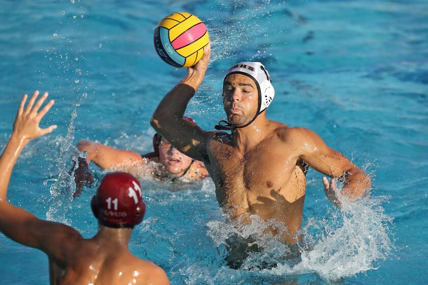 Huntington's Cooper Haddad shoots and scores over Laguna Beach defender William Kelly during Surf League water polo match on Wednesday.