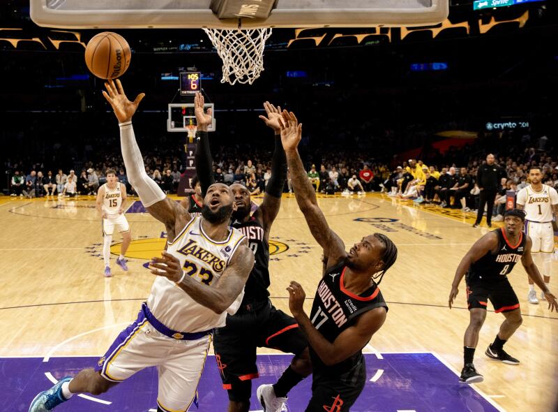 LeBron James drives to the basket to score in front of Houston Rockets forwards Jeff Green (32) and Tari Eason.