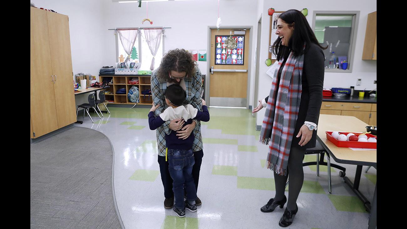 Principal for a day Nina Howe, left, gets a hug from five-year old Asatur Asatyran in the pre-school-to-second grade classroom as real principal Jay Schwartz looks on at right, during Principal For A Day at College View School, in Glendale on Tuesday, Dec. 5, 2017. Howe is the fund development and community partnerships director at the Alex Theater.