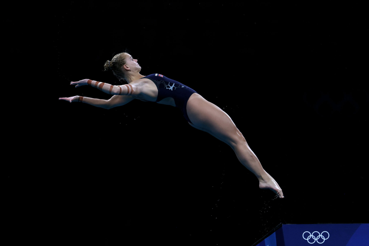 Diver Anne Tuxen of Team Norway competes with tape visible on her arm.