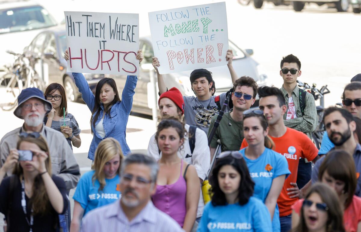 Demonstrators march, some holding signs. 