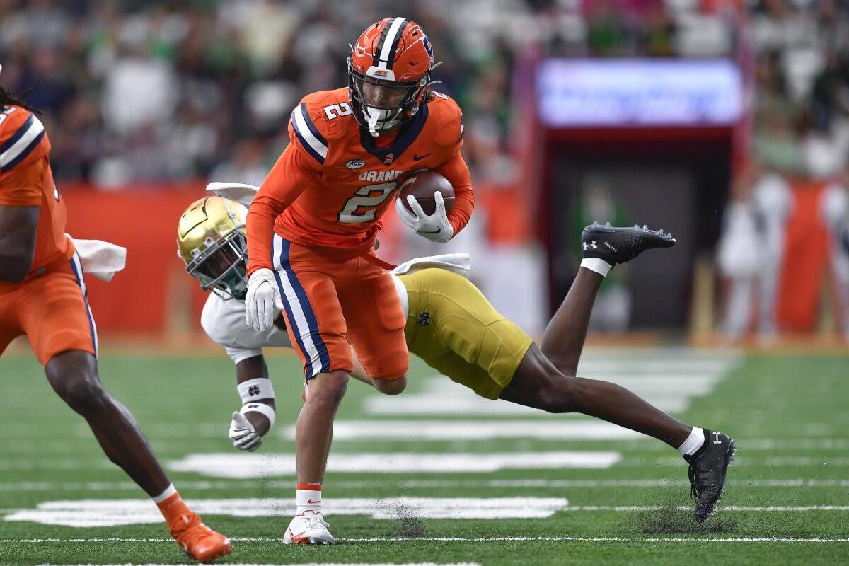 Syracuse wide receiver Trebor Pena (2) breaks a tackle by Notre Dame cornerback Cam Hart (5) during the first half of an NCAA college football game in Syracuse, N.Y., Saturday, Oct. 29, 2022. (AP Photo/Adrian Kraus)