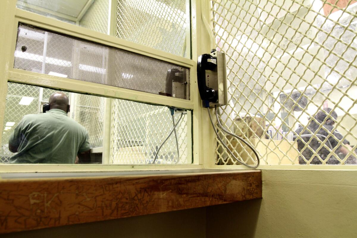 A visitor talks to a felony floor prisoner in the visiting area of LAPD's Metropolitan Jail.
