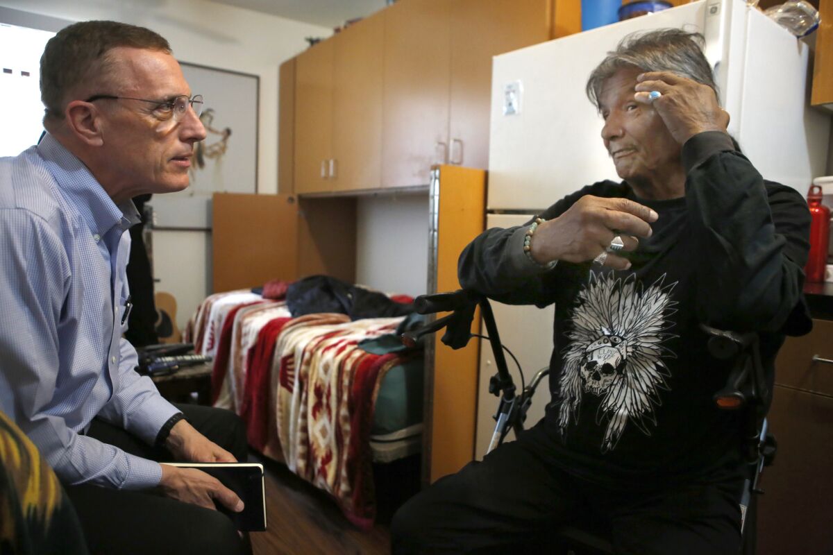 Rep. Timothy F. Murphy (R-Pa.), left, speaks with Richard LaRush in LaRush's Step Up on Second apartment. (Christian K. Lee / Los Angeles Times)