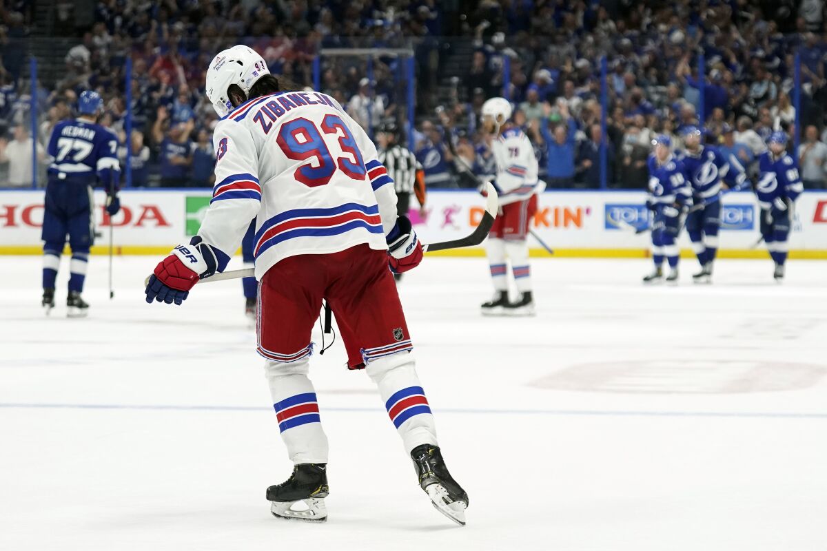 New York Rangers center Mika Zibanejad (93) skates off as members of the Tampa Bay Lightning celebrate a goal by Ondrej Palat during the third period in Game 4 of the NHL hockey Stanley Cup playoffs Eastern Conference finals Tuesday, June 7, 2022, in Tampa, Fla. (AP Photo/Chris O'Meara)
