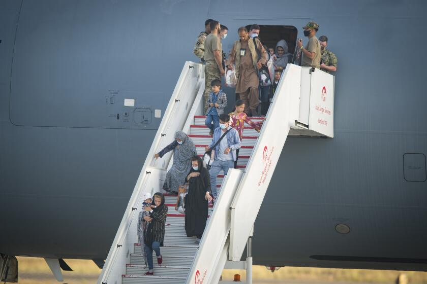 Evacuees from Afghanistan disembark from a U.S. airforce plane at the Naval Station in Rota, southern Spain, Tuesday Aug. 31, 2021. The United States completed its withdrawal from Afghanistan late Monday, ending America's longest war. (AP Photo/ Marcos Moreno)