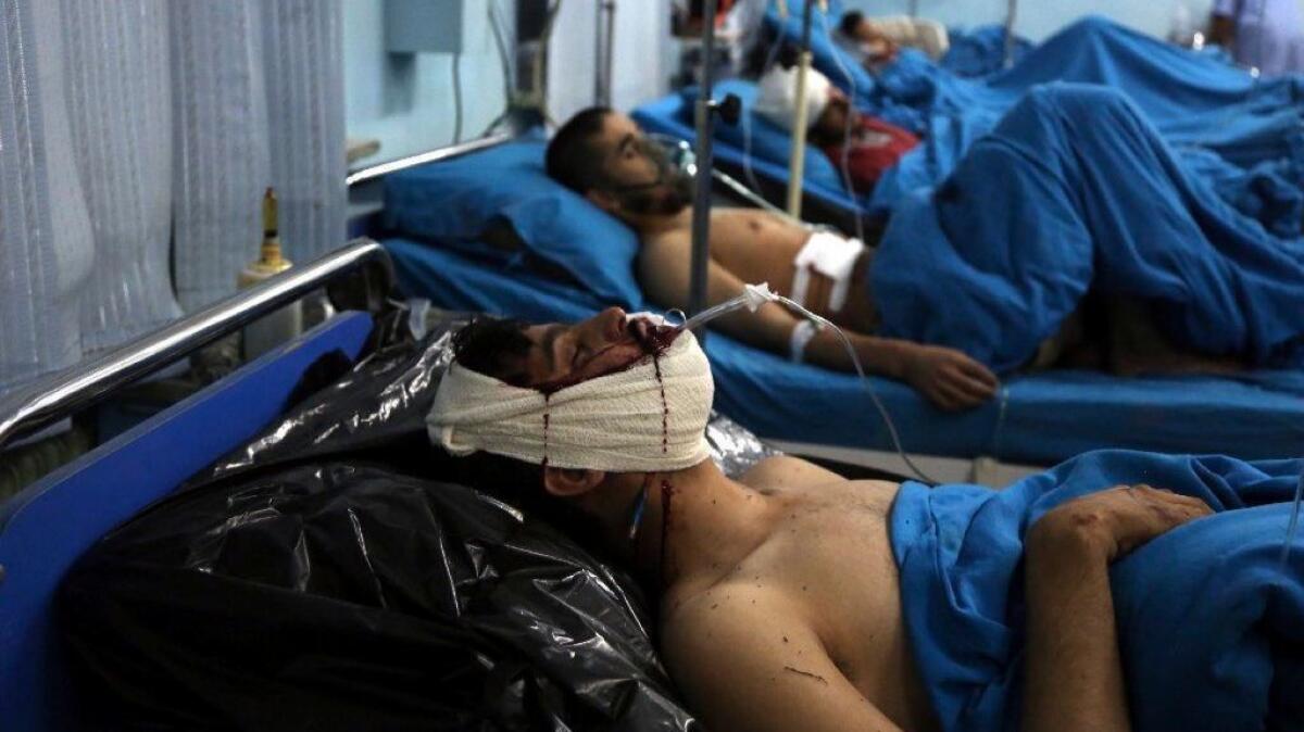 Injured men receive treatment at a hospital after a suicide bomber targeted a gathering of Muslim religious scholars in Kabul.