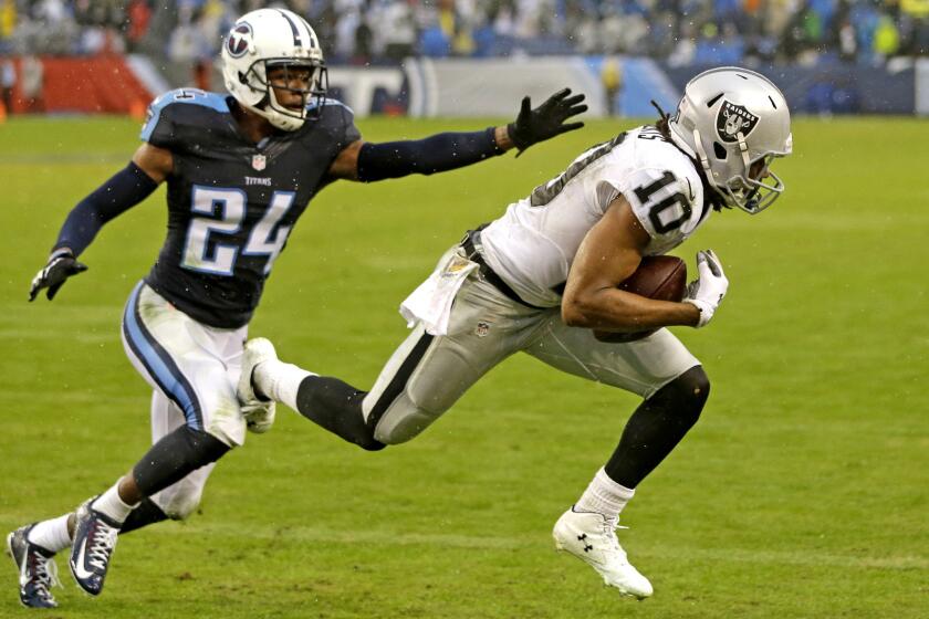 Raiders wide receiver Seth Roberts (10) catches a 12-yard touchdown pass against Titans cornerback Coty Sensabaugh in the fourth quarter Sunday.