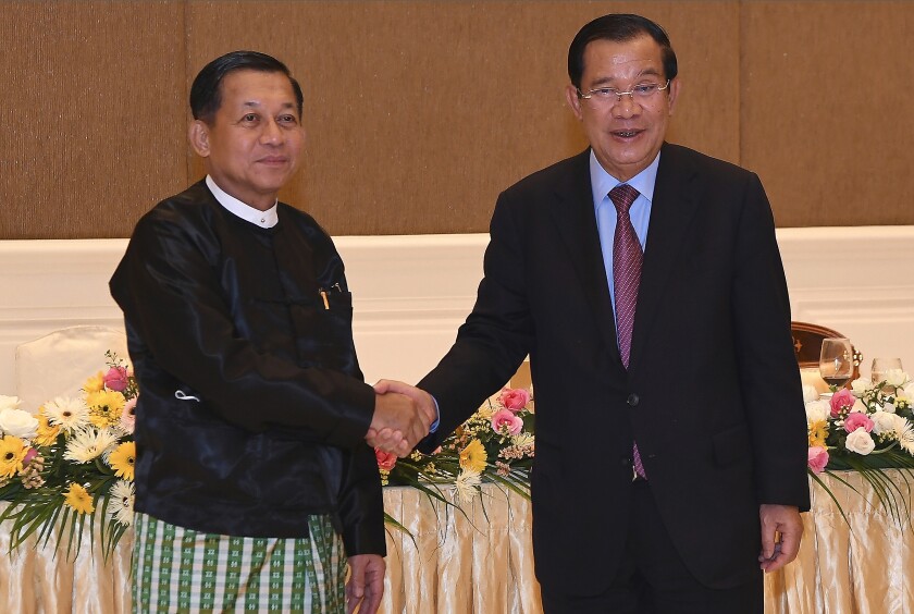 In this photo provided by An Khoun Sam Aun/National Television of Cambodia, Cambodian Prime Minister Hun Sen, right, shakes hands with Myanmar State Administration Council Chairman, Senior General Min Aung Hlaing, left, during after a meeting in Naypyitaw, Myanmar, Friday Jan. 7, 2022. Cambodian Prime Minister Hun Sen's visit to Myanmar seeking to revive peace efforts after last year's military takeover has provoked an angry backlash among critics, who say he is legitimizing the army's seizure of power. (An Khoun SamAun/National Television of Cambodia via AP)