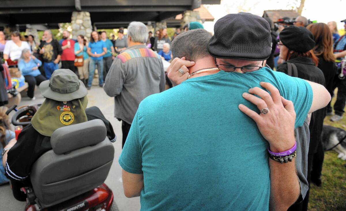 Ryan Reyes, boyfriend of San Bernardino shooting victim Daniel Kaufman, gets a hug during a memorial in Irwindale in December.