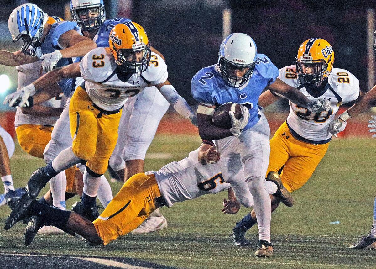 Crescenta Valley High's Maximus Grant runs between and ahead of the Montebello defense in Thursday's nonleague game at Moyse Field.