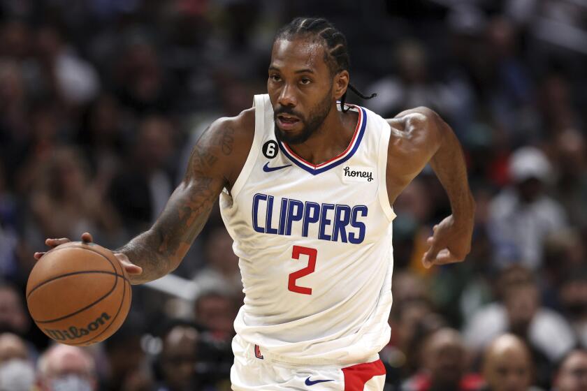 Los Angeles Clippers forward Kawhi Leonard dribbles down the court during the first half of a preseason.