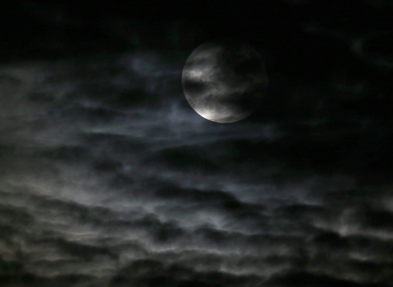 Clouds obscure the so-called supermoon before a lunar eclipse Sunday, Sept. 27, 2015, in Chicago.