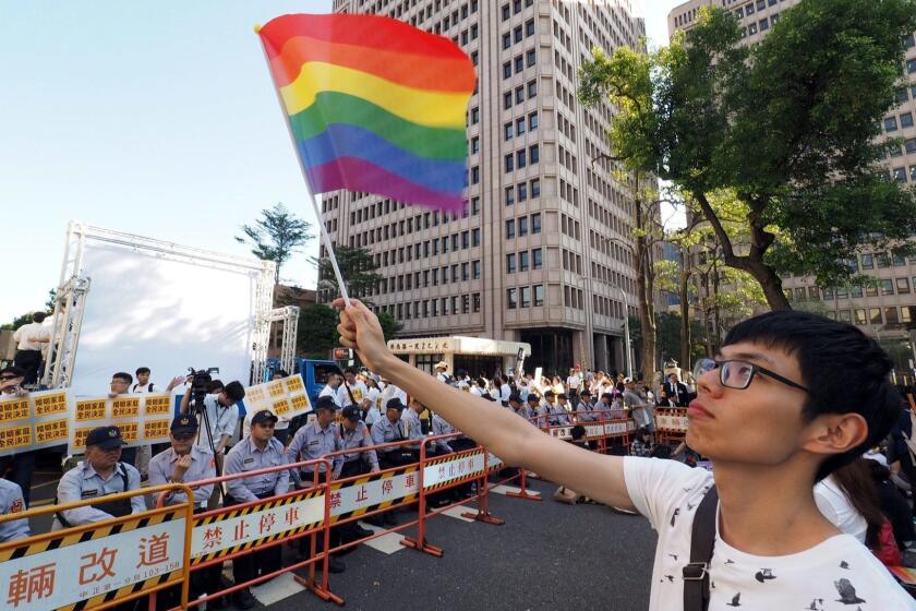 epa05634813 A young man waves a rainbow flag during a protest outside the Parliament, in Taipei, Taiwan, 17 November 2016. Reports state protesters gathered outside the parliament, both for and against a draft bill that would legalize same-sex marriage in Taiwan. If Taiwan Parliament passes the same-sex marriage bill, it will become the first Asian country to legalize same-sex marriage. EPA/DAVID CHANG ** Usable by LA, CT and MoD ONLY **