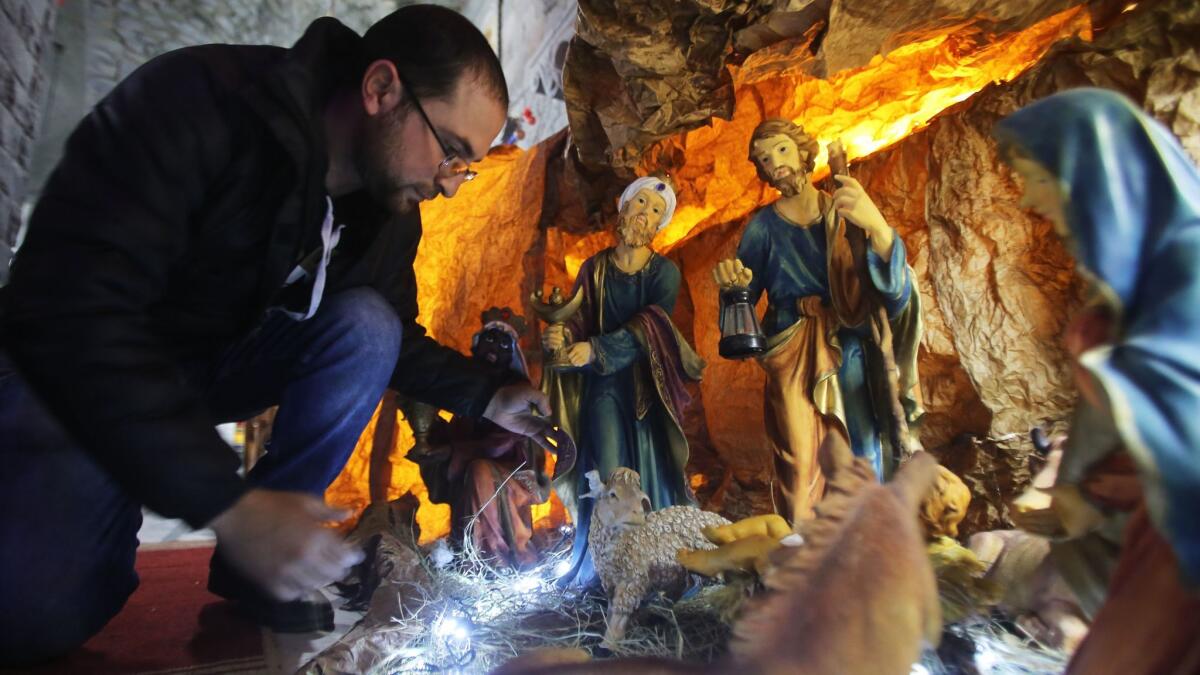 A Syrian man decorates the Saint Mary Church of the Holy Belt with a Christmas Nativity scene in the bombed-out city of Homs on Sunday.