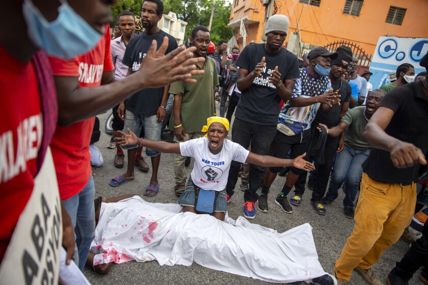 FILE - In this Dec. 10, 2020 file photo, protesters perform a simulated kidnapping during a protest to demand the resignation of Haiti's President Jovenel Moise, in Port-au-Prince, Haiti. A surge in violence is rattling Haiti and forcing families deeper into poverty to pay ransoms. (AP Photo/Dieu Nalio Chery, File)