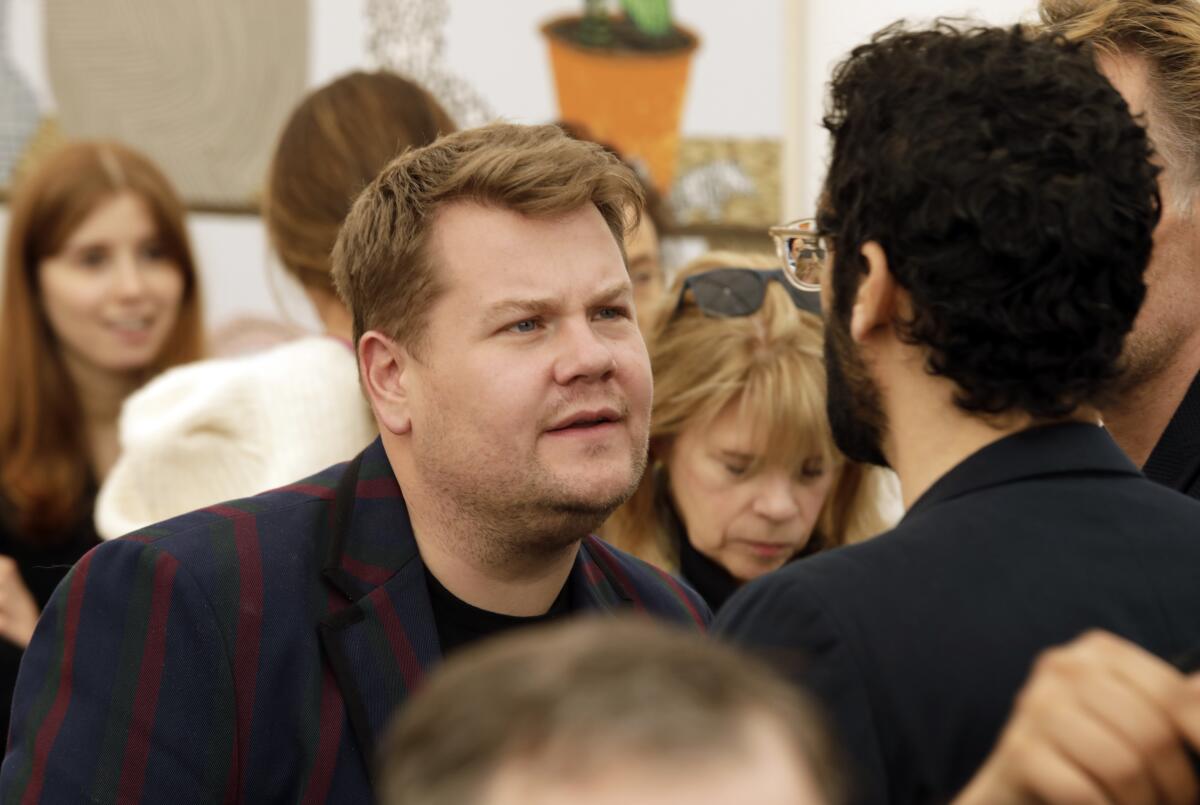 James Corden is photographed in the middle of a crowd.