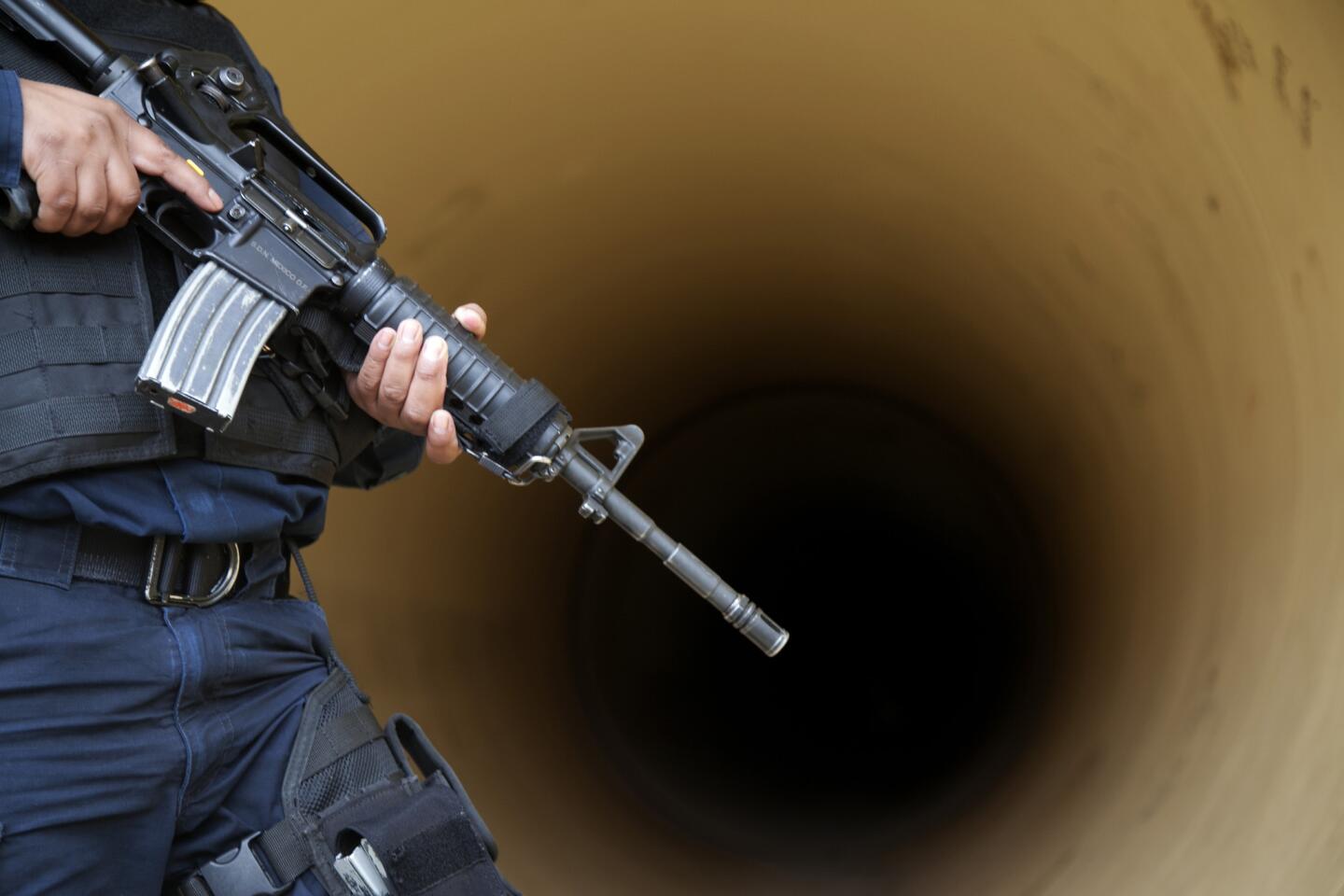 A federal police officer inspects a drainage pipe outside the Altiplano maximum security prison in Almoloya, west of Mexico City. Mexico's most powerful drug lord, Joaquin "El Chapo" Guzman, escaped from a maximum security prison through a tunnel that opened into the shower area of his cell, the country's top security official announced.