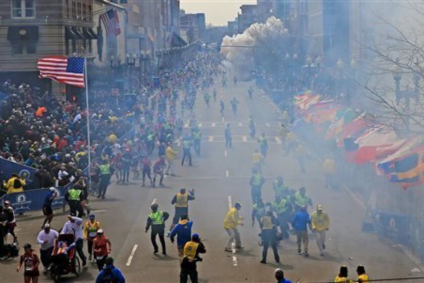 People react to explosions near the finish line of last year's Boston Marathon, which killed three spectators and injured more than 260. More stringent security measures are in place for next month's annual race.