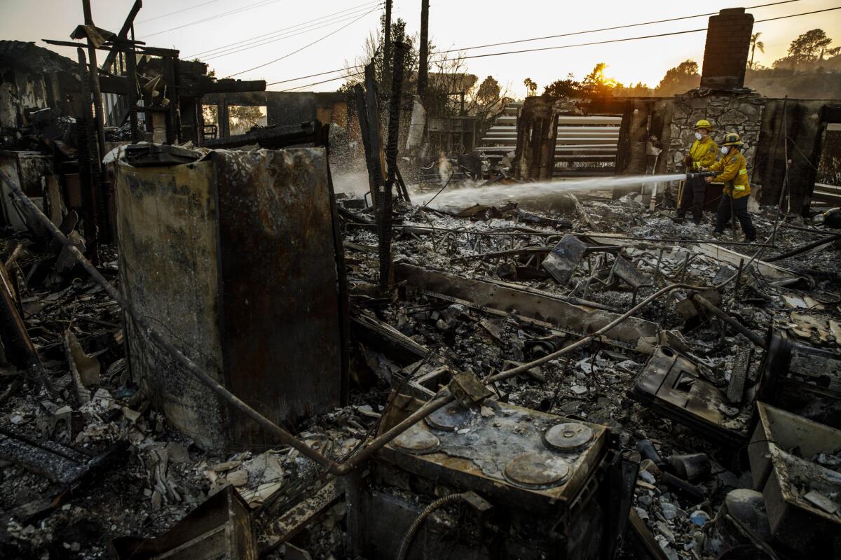 Firefighters from Los Alamitos work to put out hot spots in Ventura.