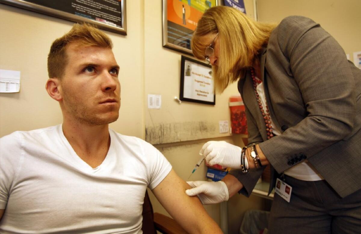 Dylan Cantrell, 27, of West Hollywood, receives a meningitis vaccination from registered nurse Karen Haughey of the AIDS Healthcare Foundation.