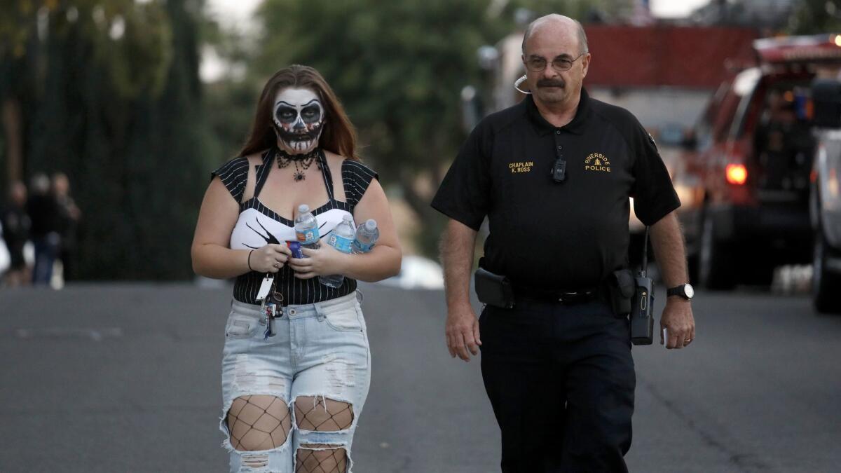 Ariana Montgomery, granddaughter of teacher Linda Montgomery, is escorted from the scene while wearing Halloween makeup.