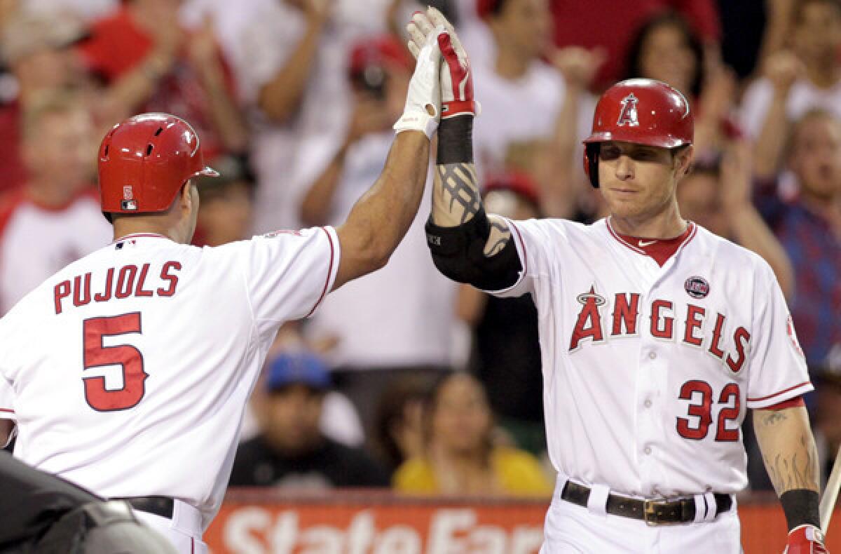 Albert Pujols and Josh Hamilton (32) -- two of top sluggers in baseball -- high-five after Pujols hit a home run against the Oakland A's last season.