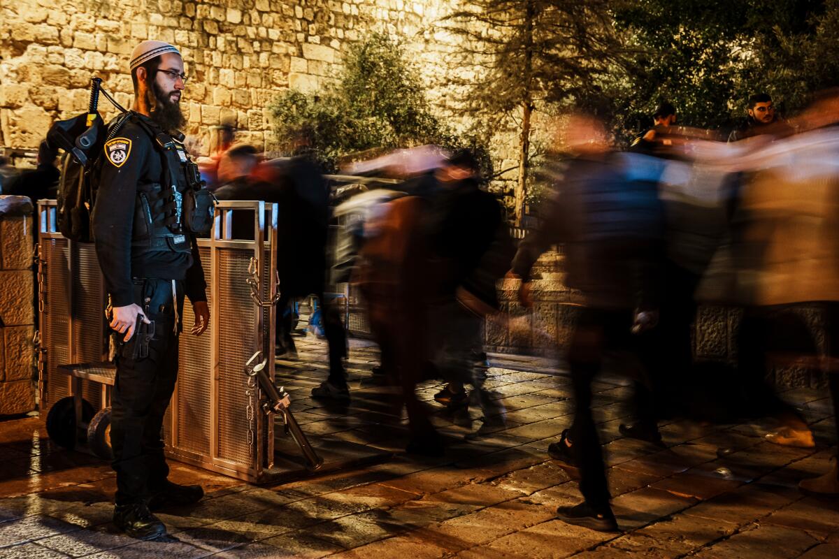 پرسنل امنیتی اسرائیل در حالی که نمازگزاران برای ورود به محوطه الاقصی صف کشیده اند، نگهبانی می دهند.