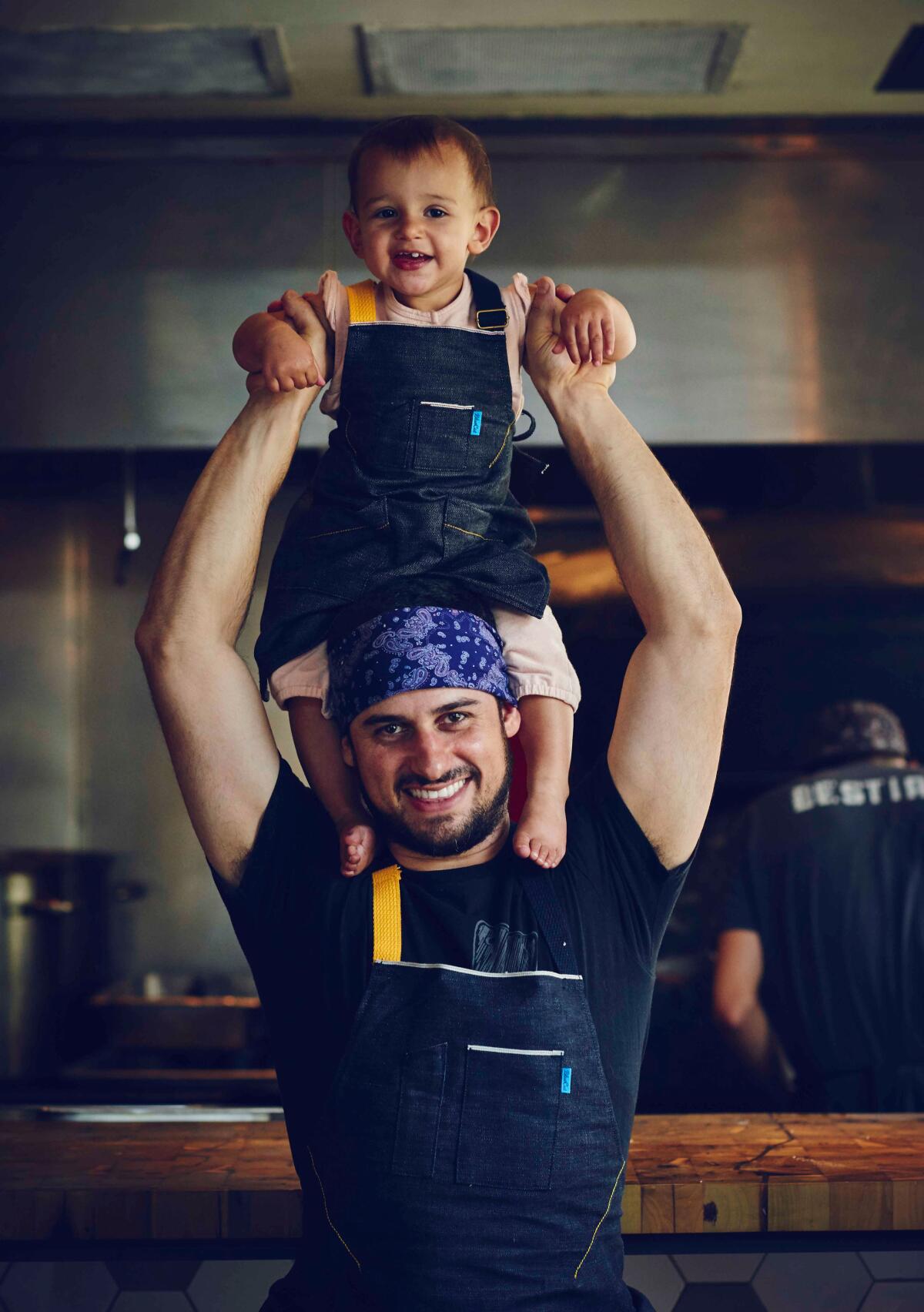 A man holds a young child on his shoulders.