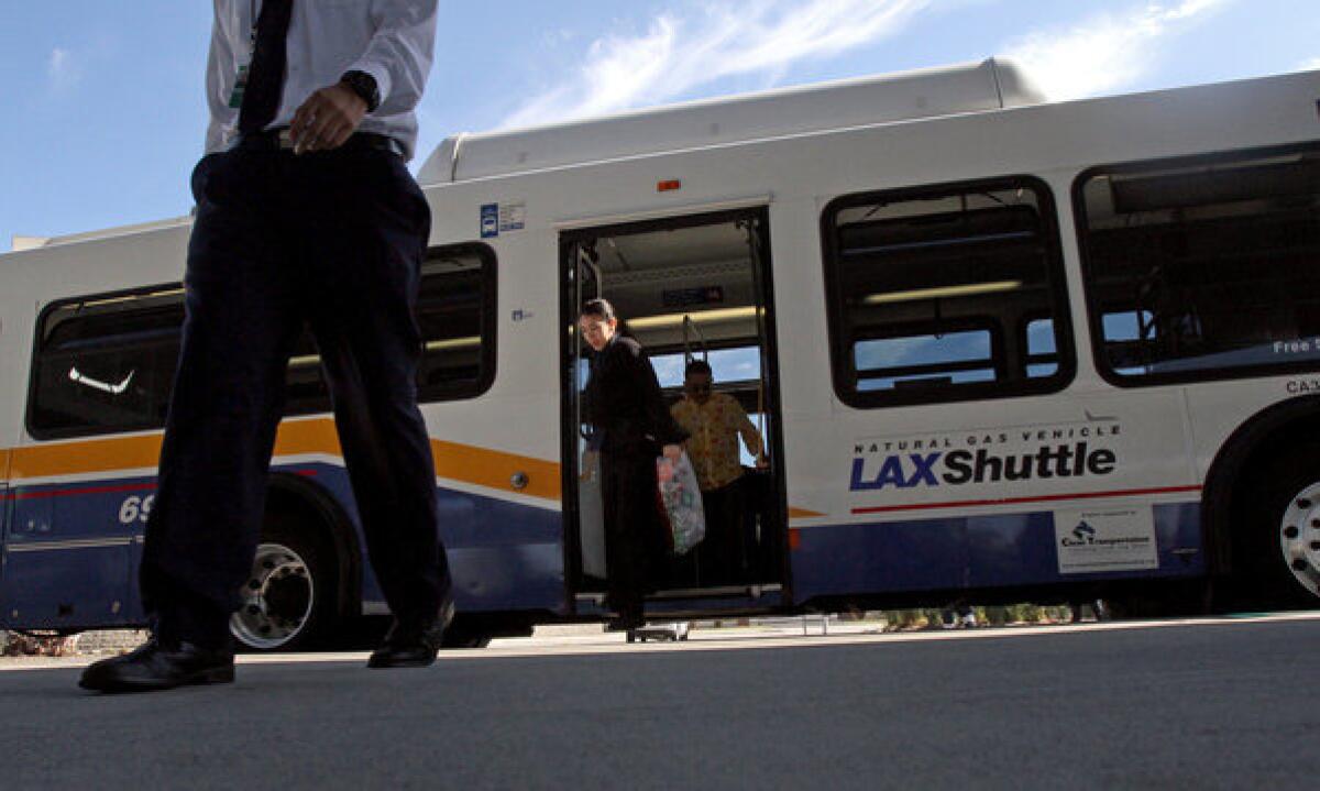 Airport employees get off the LAX Shuttle bus in Los Angeles.