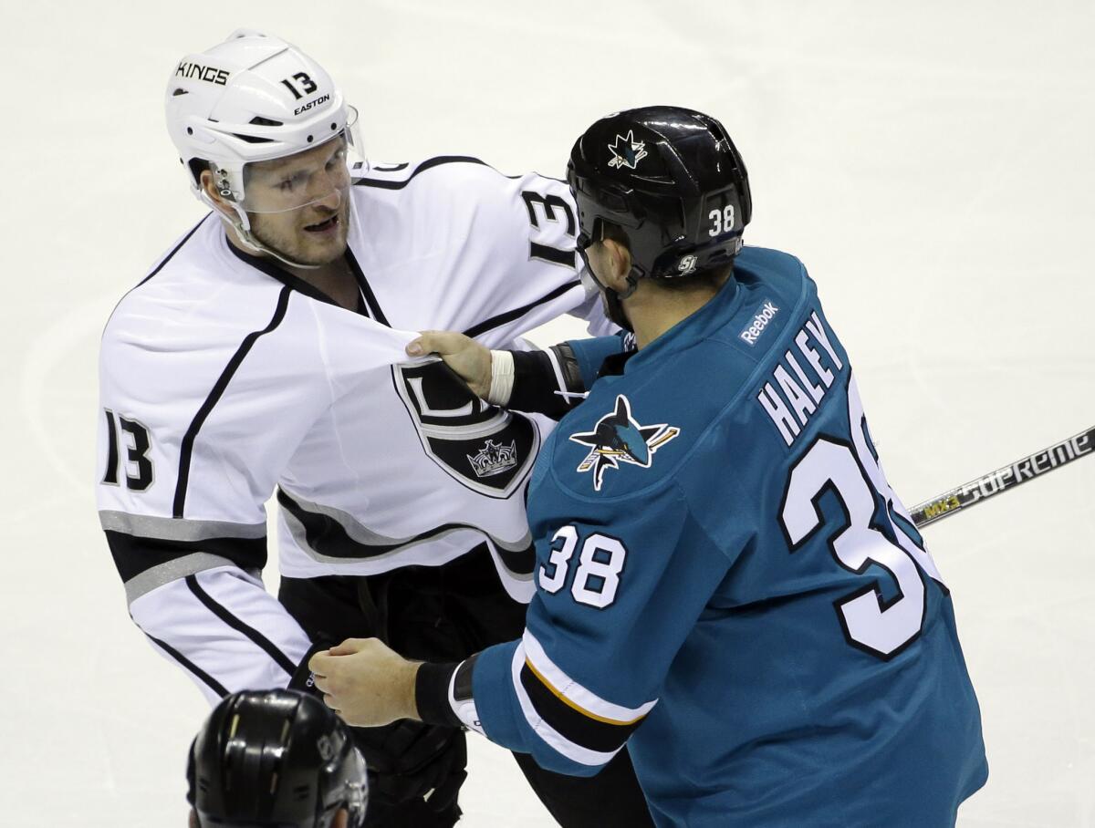 Sharks center Micheal Haley (38) grabs Kings forward Kyle Clifford (13) during the first period of a March 28 game.