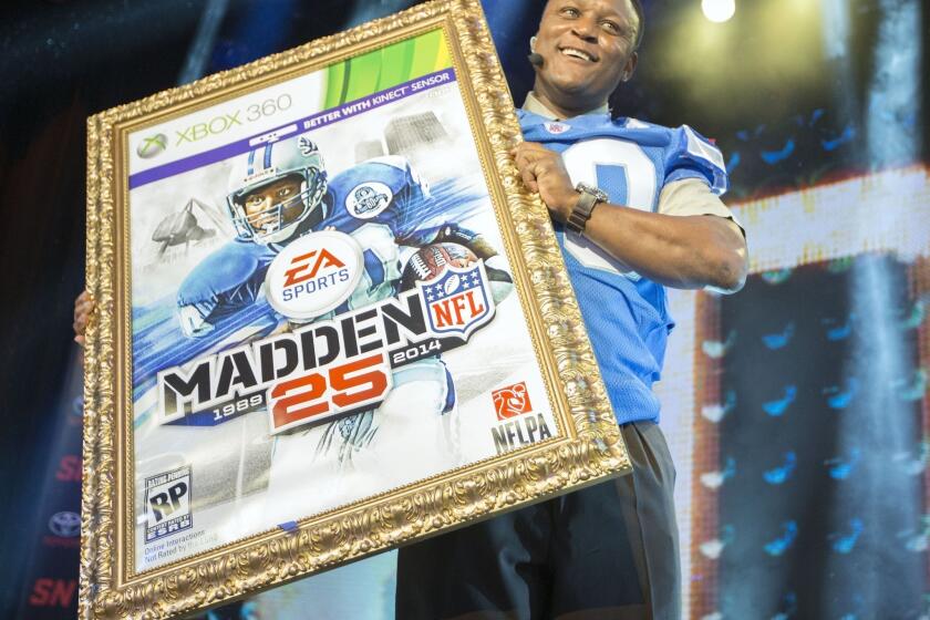 Hall of Fame running back Barry Sanders holds up a mock-up of the Madden 25 video game cover during the EA Sports Madden NFL 25 cover reveal Wednesday on SportsNation in New York City.