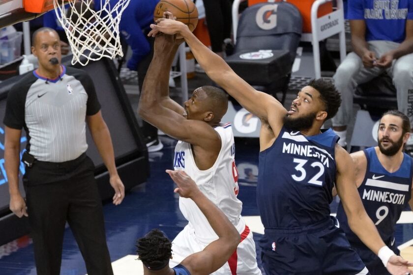 Minnesota Timberwolves' Karl-Anthony Towns (32) attempts to block a shot by Los Angeles Clippers' Serge Ibaka (9) during the first half of an NBA basketball game Wednesday, Feb. 10, 2021, in Minneapolis. (AP Photo/Jim Mone)