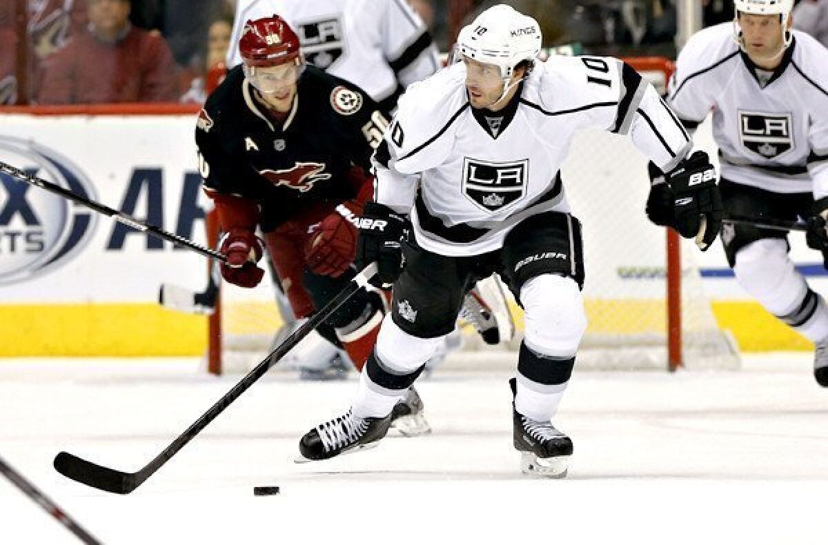 Kings center Mike Richards pushes the puck up the ice ahead of Coyotes center Antoine Vermette during a game last month.