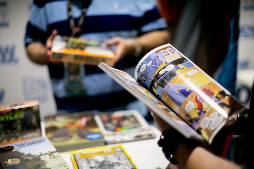 A person flips through a comic book at the IDW Publishing at Comic-Con International in San Diego.
