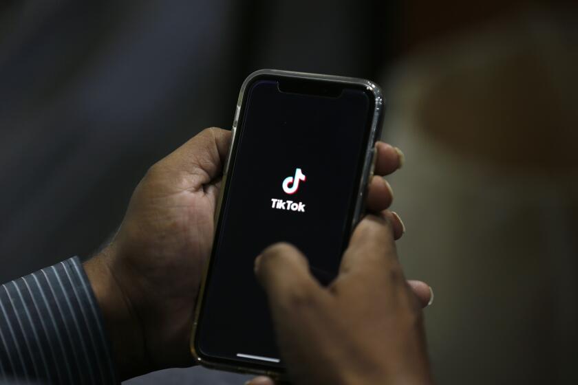 FILE - In this July 21, 2020 file photo, a man opens social media app 'TikTok' on his cell phone, in Islamabad, Pakistan. Walmart said Thursday, Aug. 27, that it's interested in teaming up with Microsoft to buy the U.S. business of TikTok, the popular Chinese video app. (AP Photo/Anjum Naveed, File)